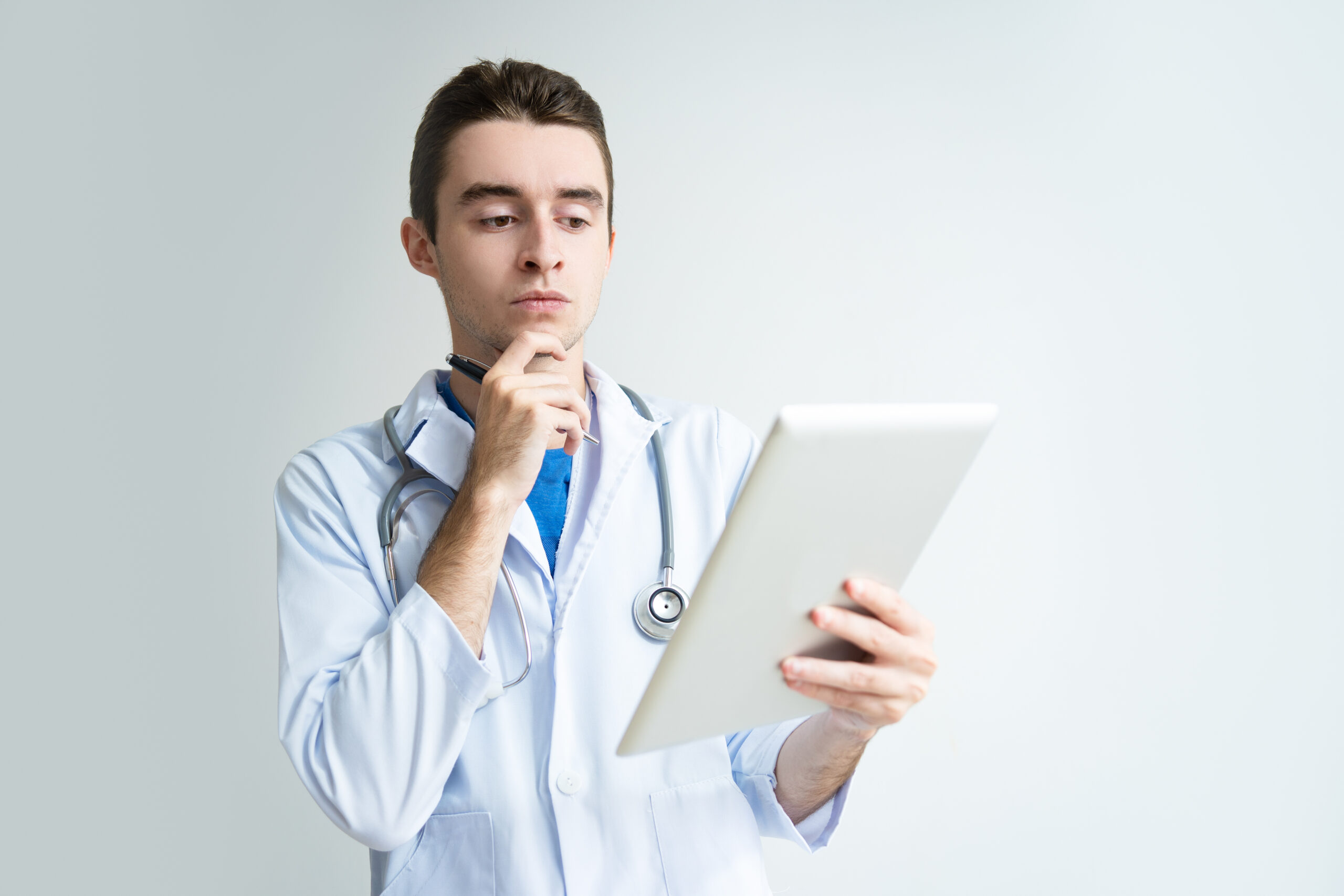 pensive young male doctor using tablet computer1 scaled